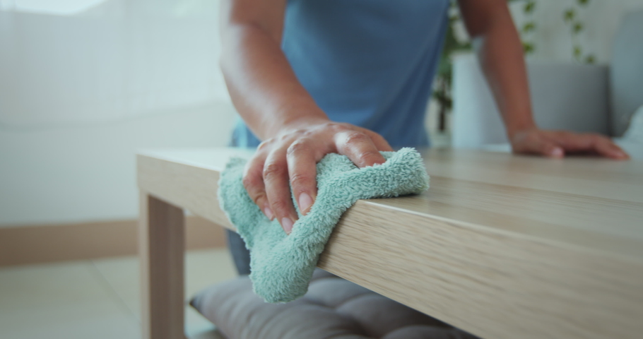 Close up on asian woman hand holding microfiber cloth cleaning and wiping the table in the living room in slow motion shot. Woman doing chores at home. Housekeeping concept. | Shutterstock HD Video #1077329588