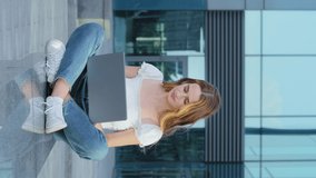 Vertical video. Young attractive millennial woman using laptop computer typing on keyboard looking at screen. Happy self-employed businesswoman receive customers orders by email, shows ok gesture.