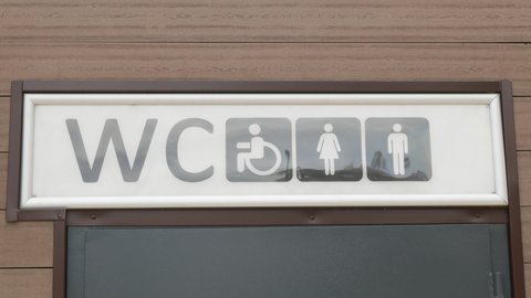Public restroom signs with disabled access symbol. Public toilet symbols with wheelchair. Restroom in park.