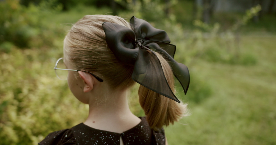 portrait cute teenage girl with black bow head accessory from the back and front