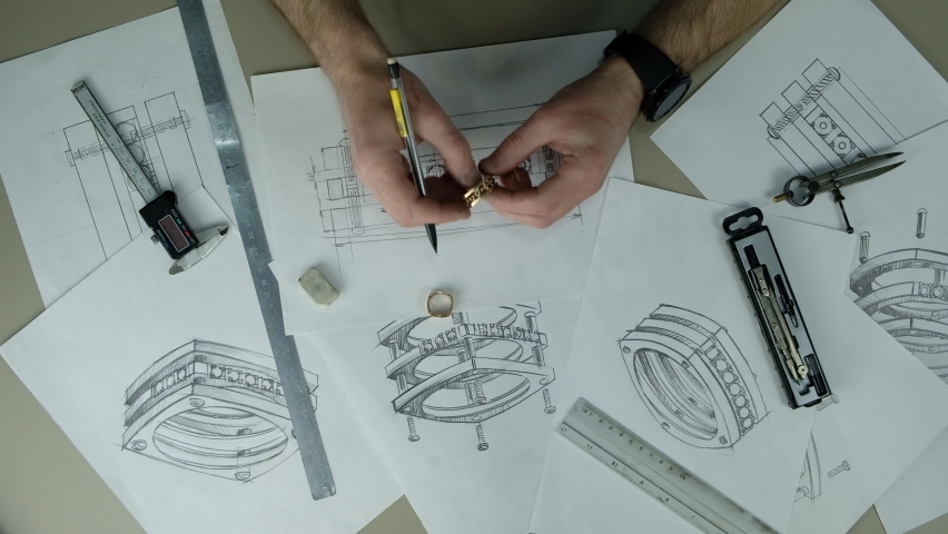 Craft goldsmith work. Portrait of young jeweler drawing a sketch of a new ring. Concept of: wedding, luxury, jewelry Royalty-Free Stock Footage #1077336050