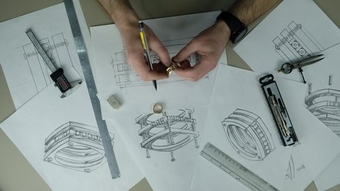 Craft goldsmith work. Portrait of young jeweler drawing a sketch of a new ring. Concept of: wedding, luxury, jewelry