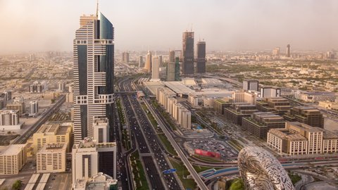 Aerial top view of highway junction with traffic timelapse in Dubai, UAE at sunset. Famous Sheikh Zayed road in Dubai downtown. Transportation and driving concept view from rooftop.