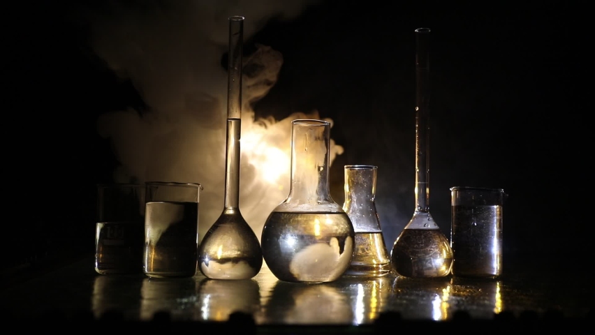 Pharmacy and chemistry theme. Test glass flask with solution in research laboratory. Science and medical background. Laboratory test tubes on dark toned background , science research equipment concept | Shutterstock HD Video #1077344207