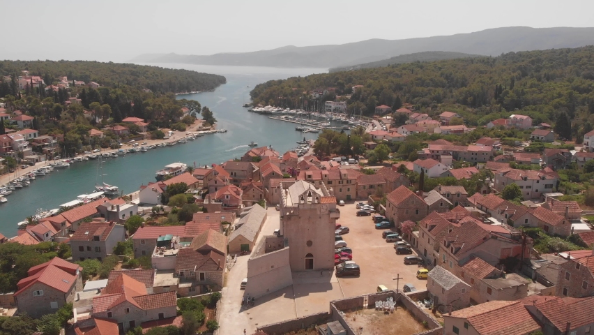 Aerial 4k video of the bay and old city with fortress and church in the town of Vrboska on Hvar island, Croatia