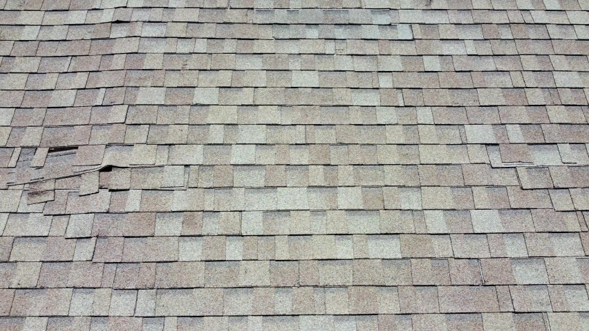 Roof with damaged shingle falling down