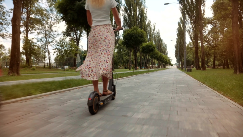 Driving Ecology Transportation. Woman Ride On Electric Scooter Mobility. E-Scooter Rider Rent Personal Eco Transport. Girl Drive Electric Scooter In City.Urban Style Riding Ecological Transport Travel Royalty-Free Stock Footage #1077362774