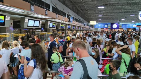 ANTALYA, TURKEY - JULY 31, 2021: huge queue inside the airport, passengers in masks stand in line for checking passports during pandemic