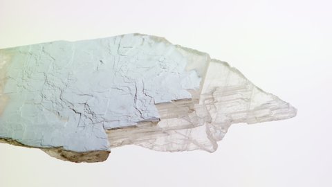 Large crystals of gypsum. Stones of plaster on a white background.
Raw material for the production of gypsum, plaster and drywall.
Renovation, construction, Drywall.  Vertical video.