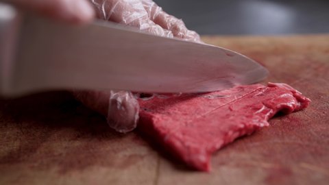 Chef Neatly Chopping Meat. The chef cuts the meat, beef close-up.