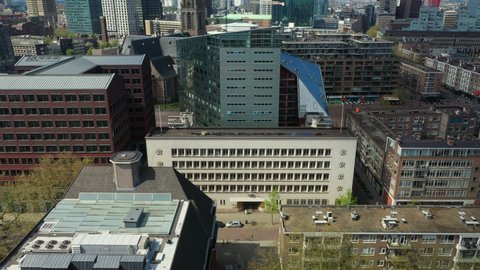 Educational Institution And City Building Along Botersloot In Rotterdam Netherlands With World Trade Center Tower In Distant Background. aerial tilt-up