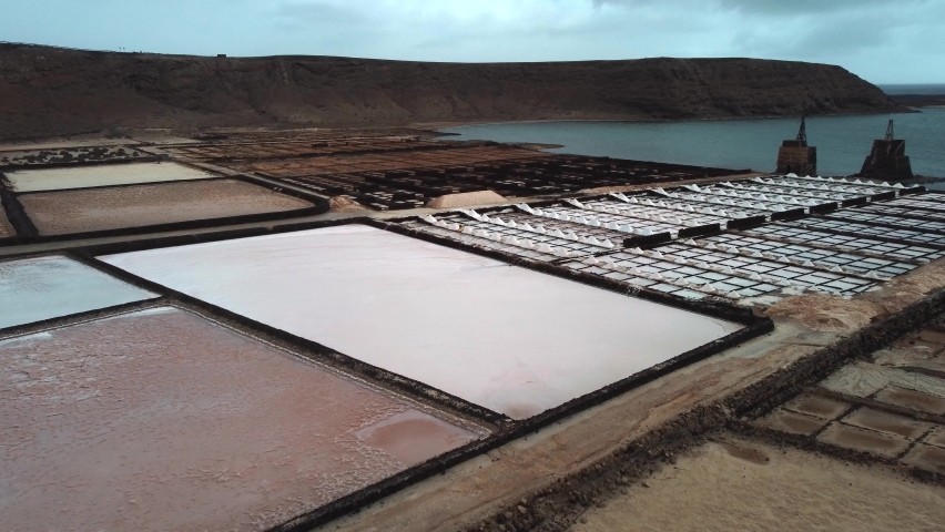 Salt Production Flats At The Waterfront Of A Blue Lagoon In Las Salinas del Janubio, Lanzarote, Spain. aerial | Shutterstock HD Video #1077378614