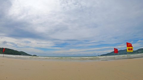 Patong beach at Phuket lockdown during sandbox project cuz Covid-19 or corona virus pandemic with Swim Here flag on cyan sea water calm n ocean wave in white cloud blue sky, 4k b-roll footage video