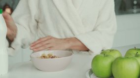 Close-up of woman in bathrobes preparing breakfast in the domestic kitchen