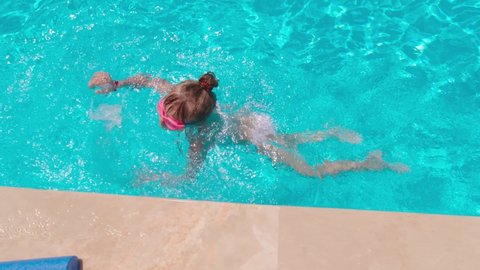 Girl learning to swim in the swimming pool