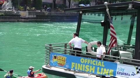 Chicago, IL - August 5th, 2021: A crew member of the Odyssey Cruise boat tosses a life ring into the river in attempt to capture a stray duck from the annual Special Olympics Illinois Ducky Derby.