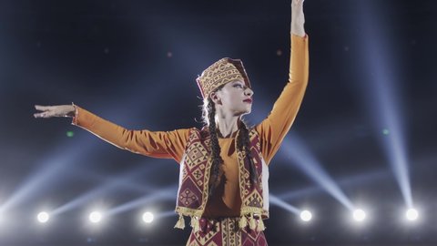 Beautiful Caucasian girl dancer perform traditional folk dance on a stage 4K. Armenian ensemble in traditional costume