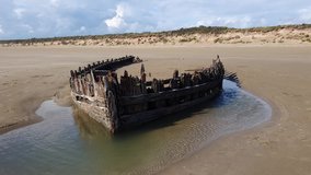 Shipwreck on the Cefn Sands beach at Pembrey Country Park in Carmarthenshire South Wales UK, which is a popular Welsh tourist travel resort and coastline landmark, video footage clip