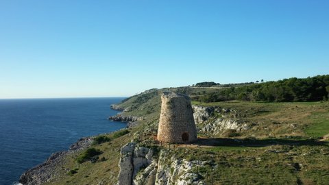 A medieval tower on the outskirts of the village of Porto Badisco by the Tyrrhenian Sea in Europe, in Italy, in the Apulia region, in the province of Lecce, in Porto Badisco, in summer, by drone.