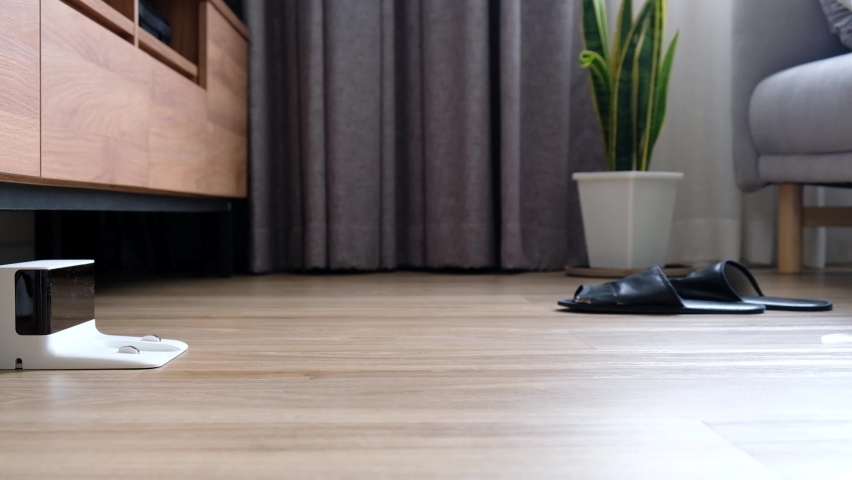 Robot Vacuum Cleaner In A Modern Living Room on wood floor from charging station 4k | Shutterstock HD Video #1077433823