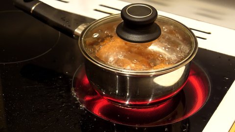 Eggs in a saucepan boiling rapidly on automatically regulating heat ceramic hob cooker.