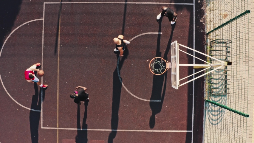 Top view of a backyard team playing basketball. Multiracial group of young guys working out professionally together.