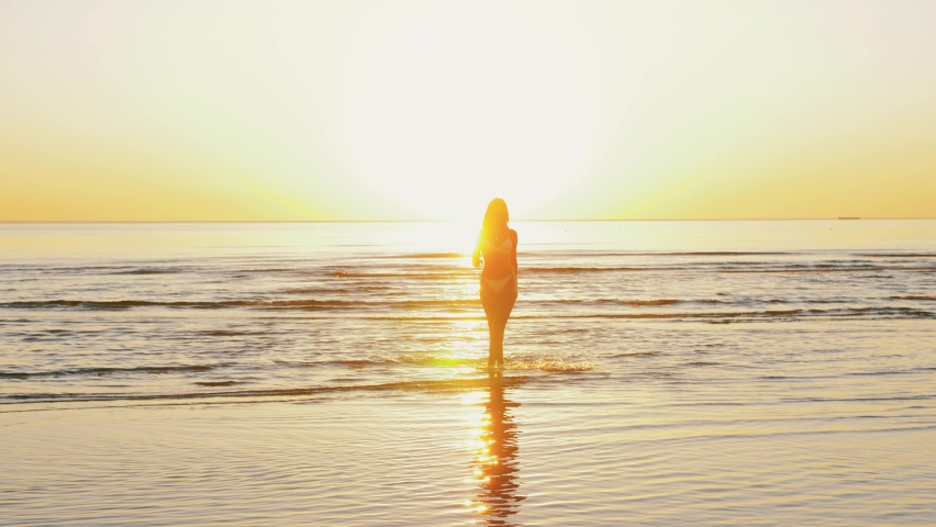 People, summer and swimwear concept - young woman in bikini swimsuit on beach | Shutterstock HD Video #1077443105