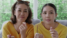 POV close-up face skin of mature elder mom and girl look at camera play fun game get dressed in asia mother day good life warm time. Cute teen people love enjoy social media app relax on sofa at home.