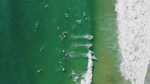 Baleal, Portugal, Europe. People on surfing boards within turquoise waters as seen from above. Aerial footage of surfers floating on waves. High quality 4k footage