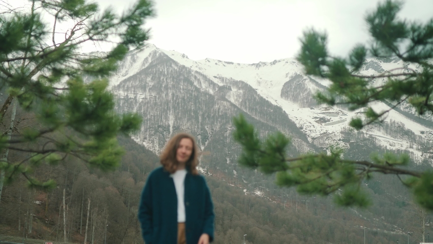 Girl in blue coat posing on camera in mountain in Roza Khutor
