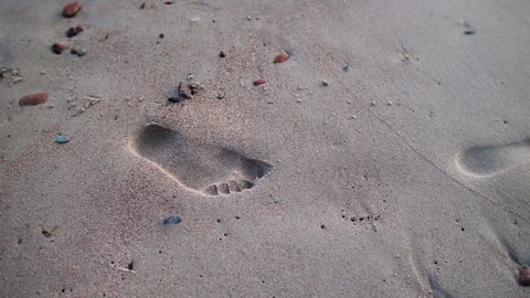 Closeup view of footprints on the  sand at beach.
