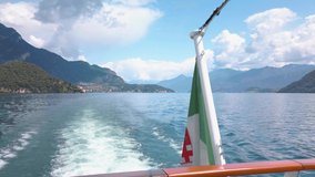 Clip of small waves on the Como lake, after a tourist ferry. The boat is sailing with tourists between the cities. It is a beautiful sunny summer day