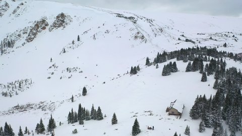 Thick Snow-Covered Mountain Slopes With Isolated Cottage In Winter Park Of Colorado. - Aerial Drone Shot