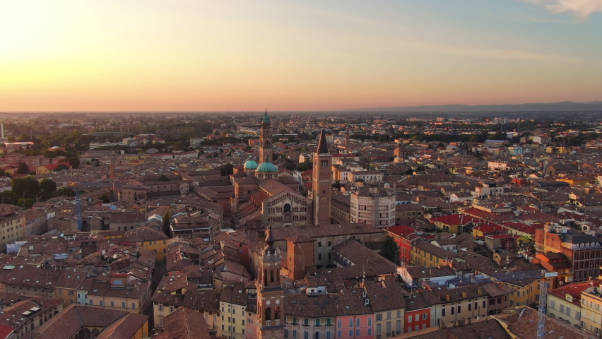 parma aerial view drone flying orbit over city centre cathedral and baptistery,wide shot of italian town cityscape at dawn