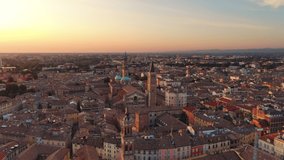 parma aerial view drone flying orbit over city centre cathedral and baptistery,wide shot of italian town cityscape at dawn