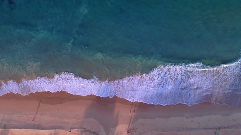 Aerial view of sea and sand beach at sunset or sunrise Amazing Wave crashing on sandy shore Pink sand beach Beautiful for holiday summer background Tropical destination High quality footage from drone