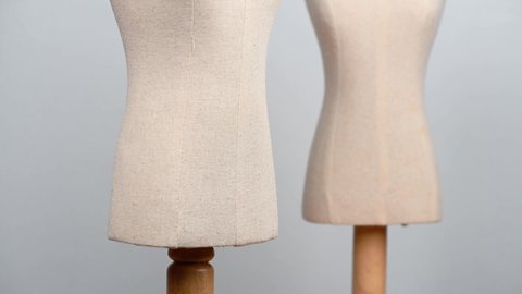 close up of a fabric and wood vintage dummy dress mannequin standing isolated without clothes on clean and clear background.
