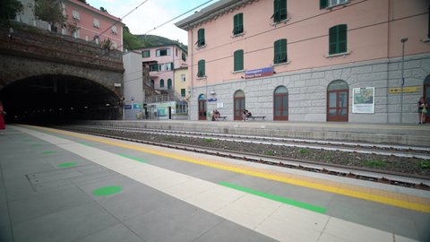 Riomaggiore, Italy - June 11. 2021: Passenger Train entering Train Station in Riomaggiore 5 Terre, Italy. Trenitalia Train in cinque terre