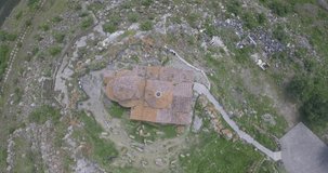 Top view of a drone flying with panning over the roof of the famous ancient monastery of Hayravank in Armenia
