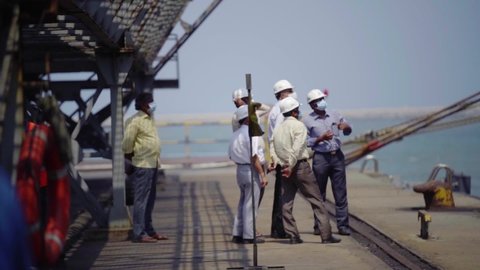 Chennai , India - 08 11 2021: Team of Engineers in development discussion at a sea terminal in sunny India