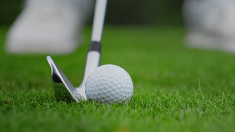 Golf club kicking the ball on green grass close up