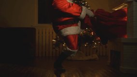 Santa Claus with bag of gifts crawls out of fireplace at Christmas or New Year. - Powered by Shutterstock - Get 15% off with code: PIKWIZARD15