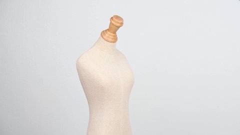 close up of a fabric and wood vintage dummy dress mannequin standing isolated without clothes on clean and clear background.