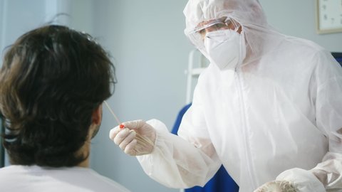 PCR test process, Doctor wearing protective suit and gloves taking sample from nose of patient for antigen coronavirus test, express covid-19 testing for traveling in airport, safety protection