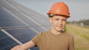 Little boy in a protective helmet at a solar power plant. The concept of children and green energetics. Children for clean energy. Shooting at a solar power plant. Ecological farm. Solar power station - Powered by Shutterstock - Get 15% off with code: PIKWIZARD15