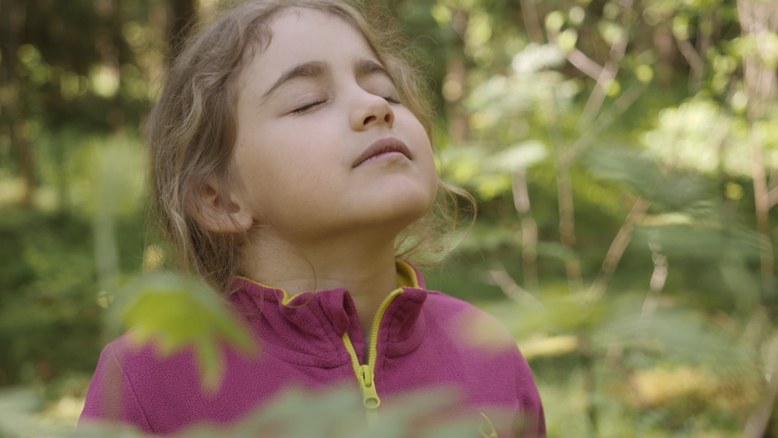 Portrait Child Girl Exhaling Fresh Air, Taking Deep Breath, Reducing Stress in Forest. Dreamy Peaceful Relaxed Smiling Kid Girl Breathing Fresh Air Nature, Tranquil Caucasian Child Alone Outdoors. | Shutterstock HD Video #1077530213