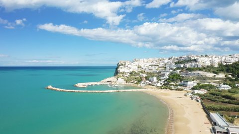 The town of Peschici, its marina and its fine sandy beach by the Tyrrhenian Sea in Europe, in Italy, in the Apulia region, in the province of Foggia, in Peschici