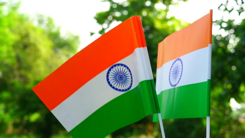 Two Indian national Tricolor flag holding in hand. Independence Day and Republic Day of India. Flying Indian Tiranga flag close-up view, 15 August.