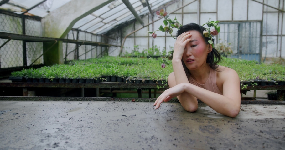 Dirty girl. Beautiful asian woman with flowers in her hair is tired 