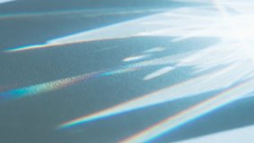 Sharp Beams from Lens Edges. Loop. The optical lens system creates a series of bright, changing geometric highlights on a light surface - Powered by Shutterstock - Get 15% off with code: PIKWIZARD15